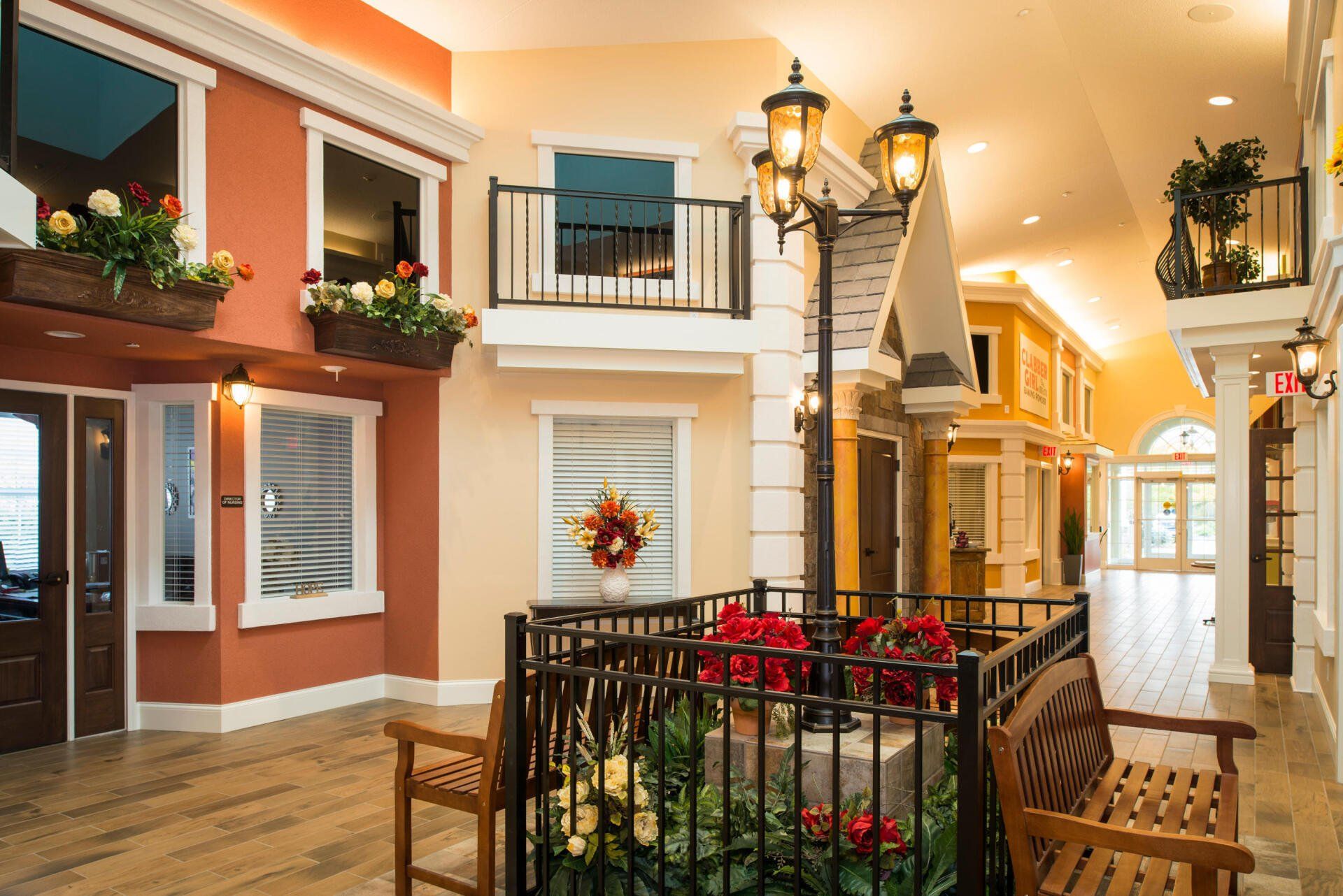Indoor hallway designed like a miniature street, featuring terracotta-colored facades, balconies, benches, and lanterns.