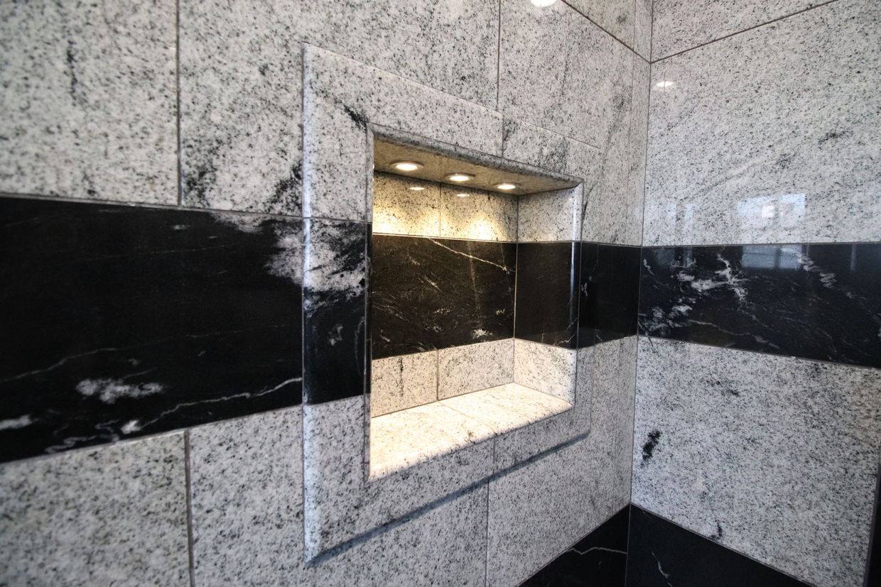 Finished luxury bathroom with natural stone walls and a recessed niche