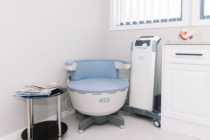 A Chair is Sitting in a Room Next to a Table and a Machine — Renew Laser Clinic in Taree, NSW