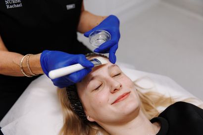 A Woman is Laying on a Bed Getting a Facial Treatment — Renew Laser Clinic in Taree, NSW