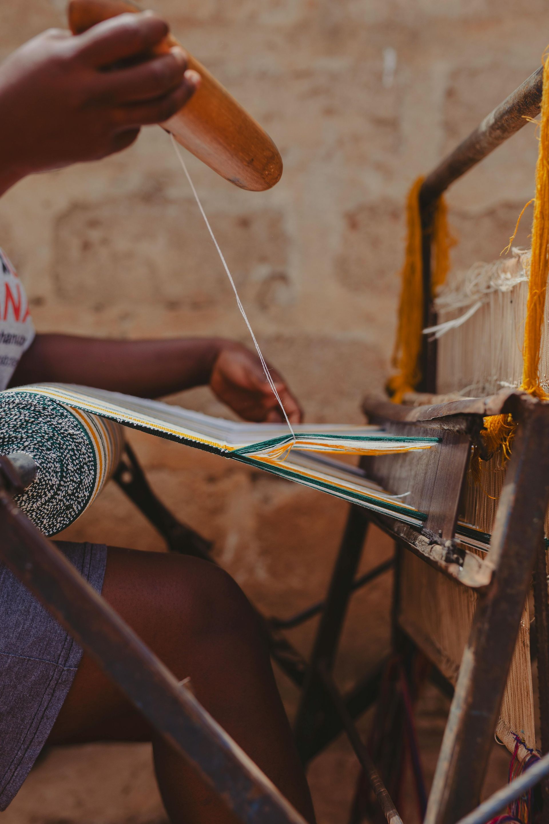 A person is weaving kente cloth in Ghana