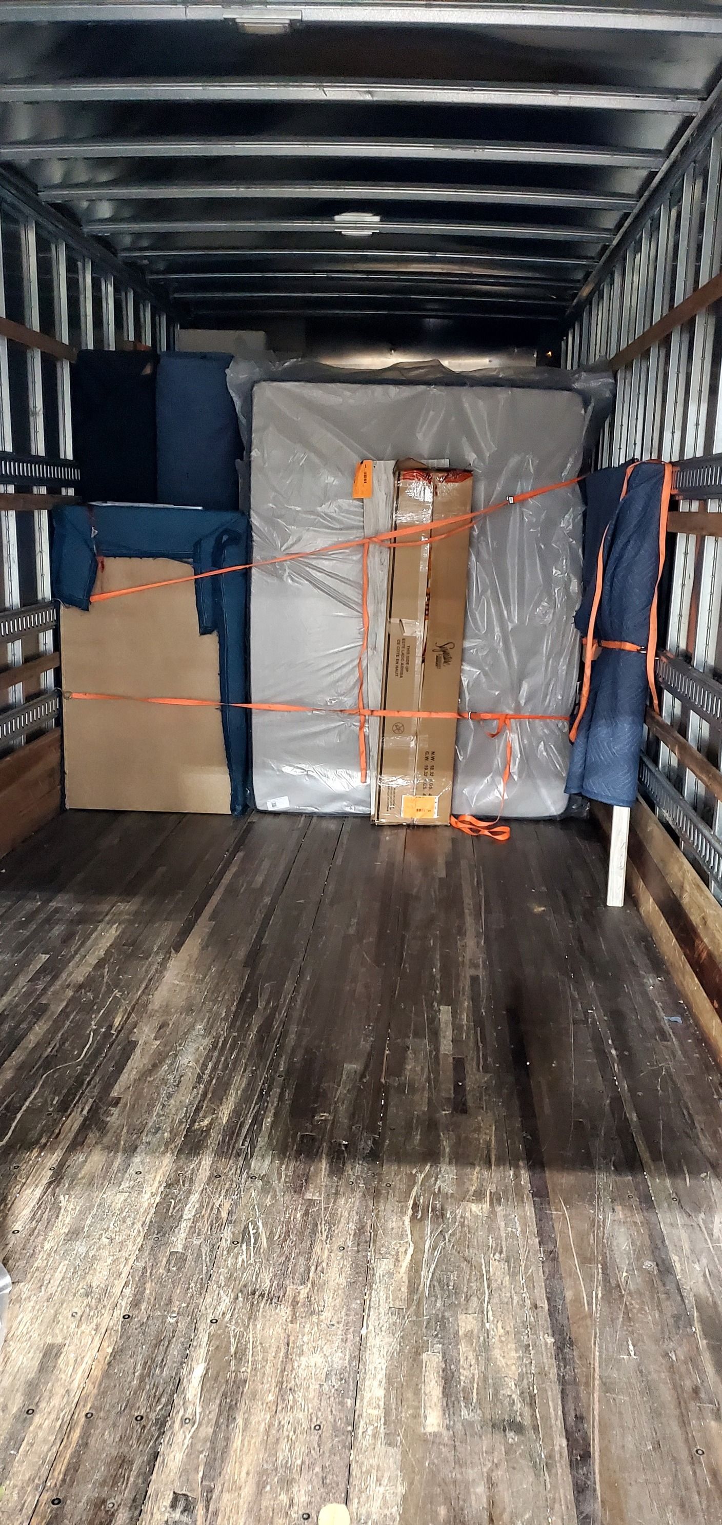 The inside of a moving truck filled with furniture and boxes.