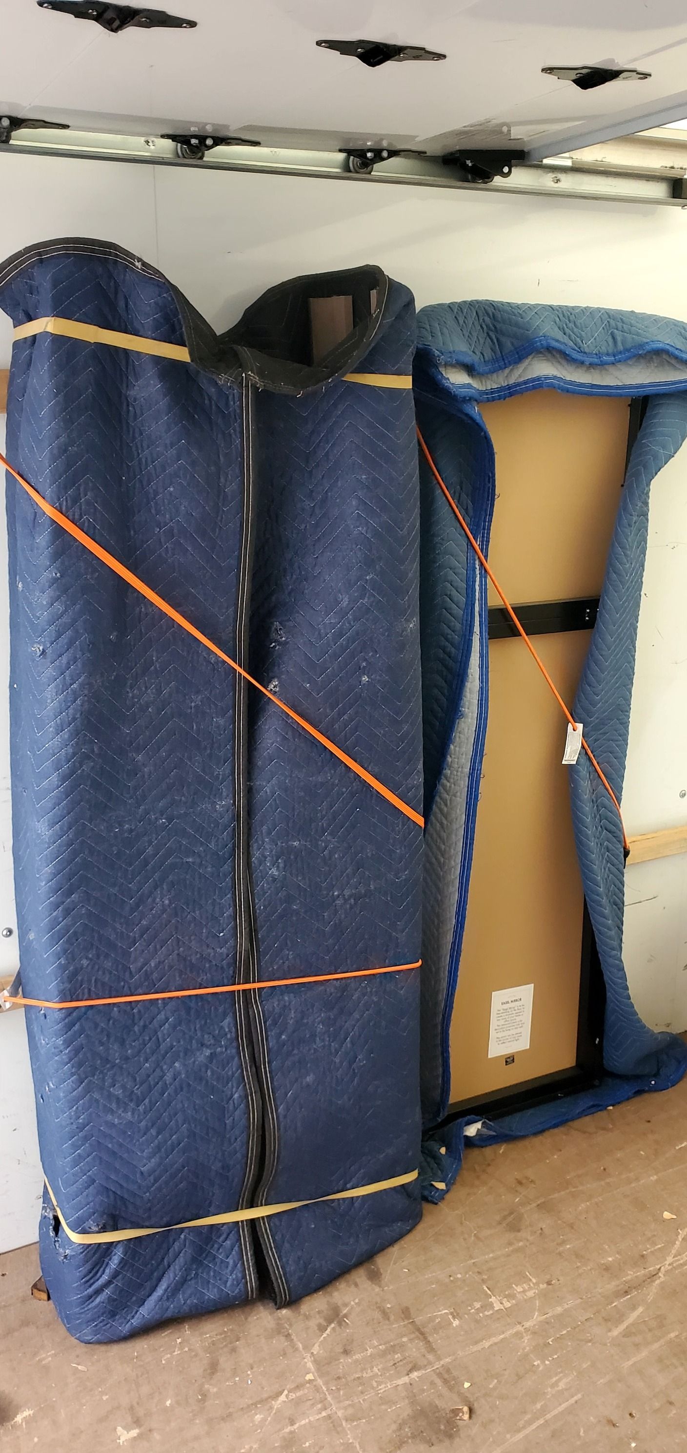 A piece of furniture is wrapped in a blue blanket.