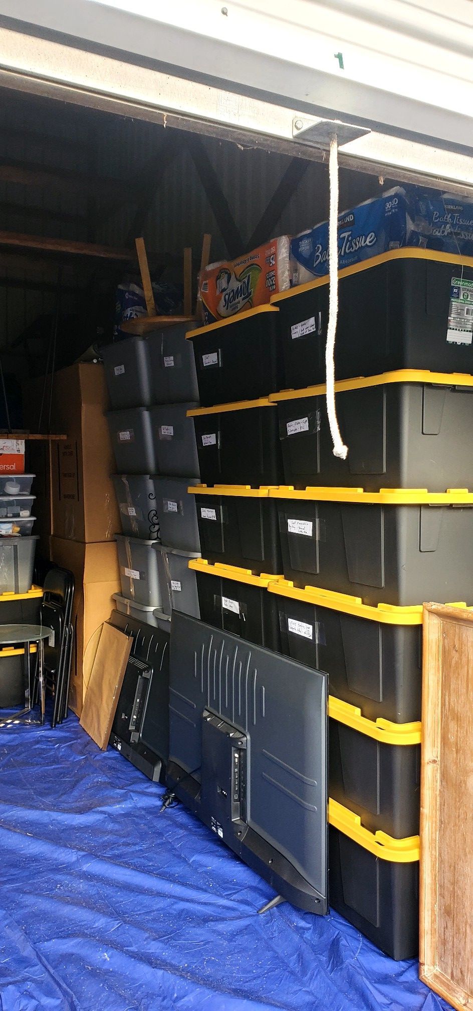 A garage filled with lots of boxes and a television.