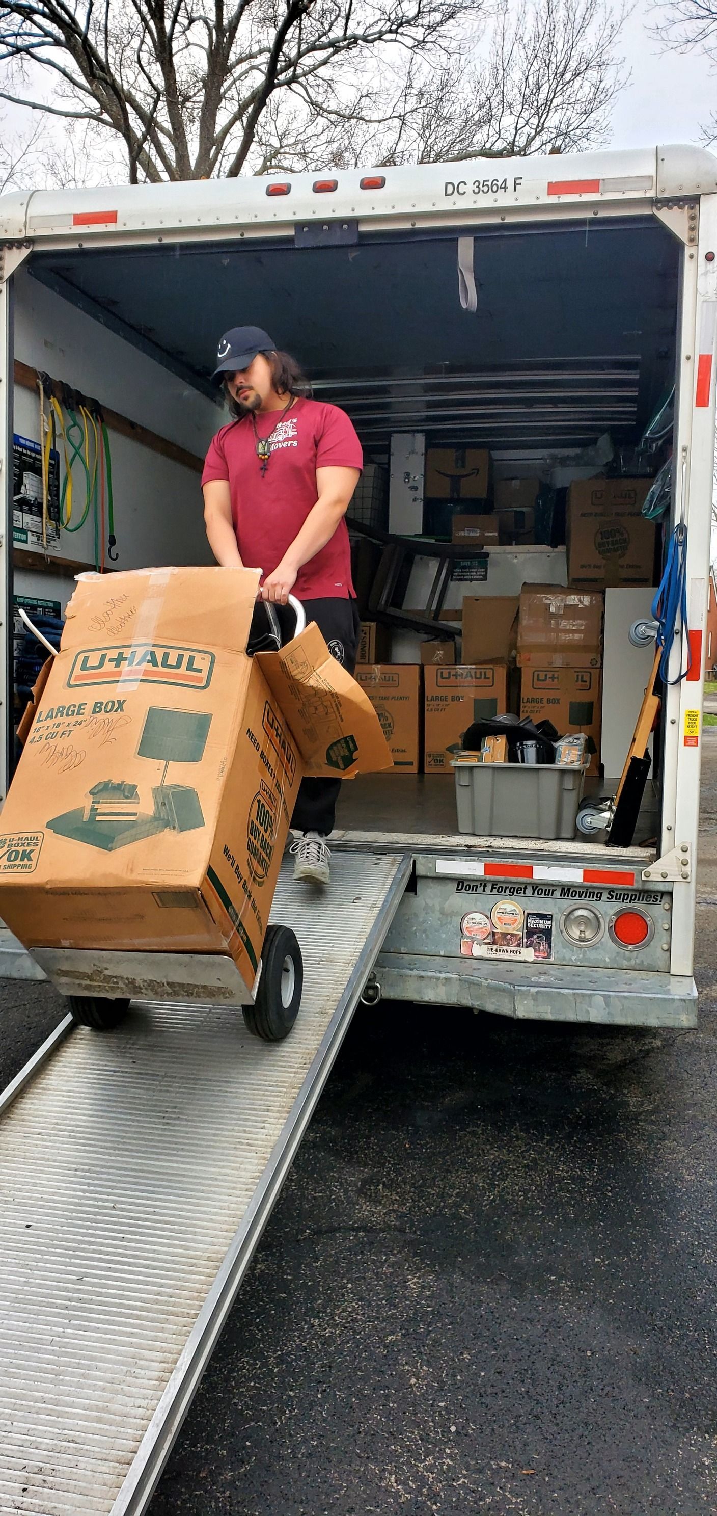A man is loading a box into a moving truck.