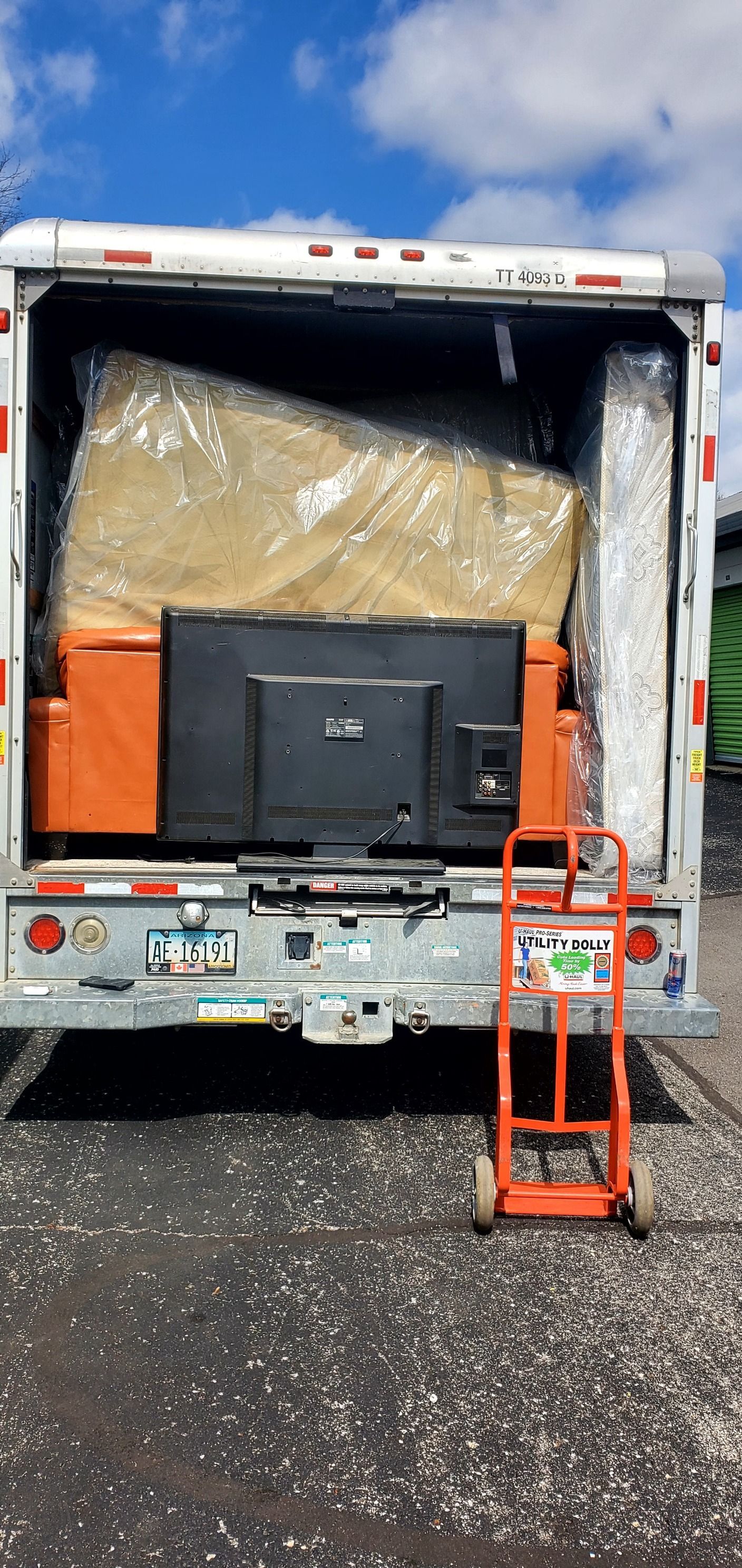 A moving truck is loaded with furniture and a television.