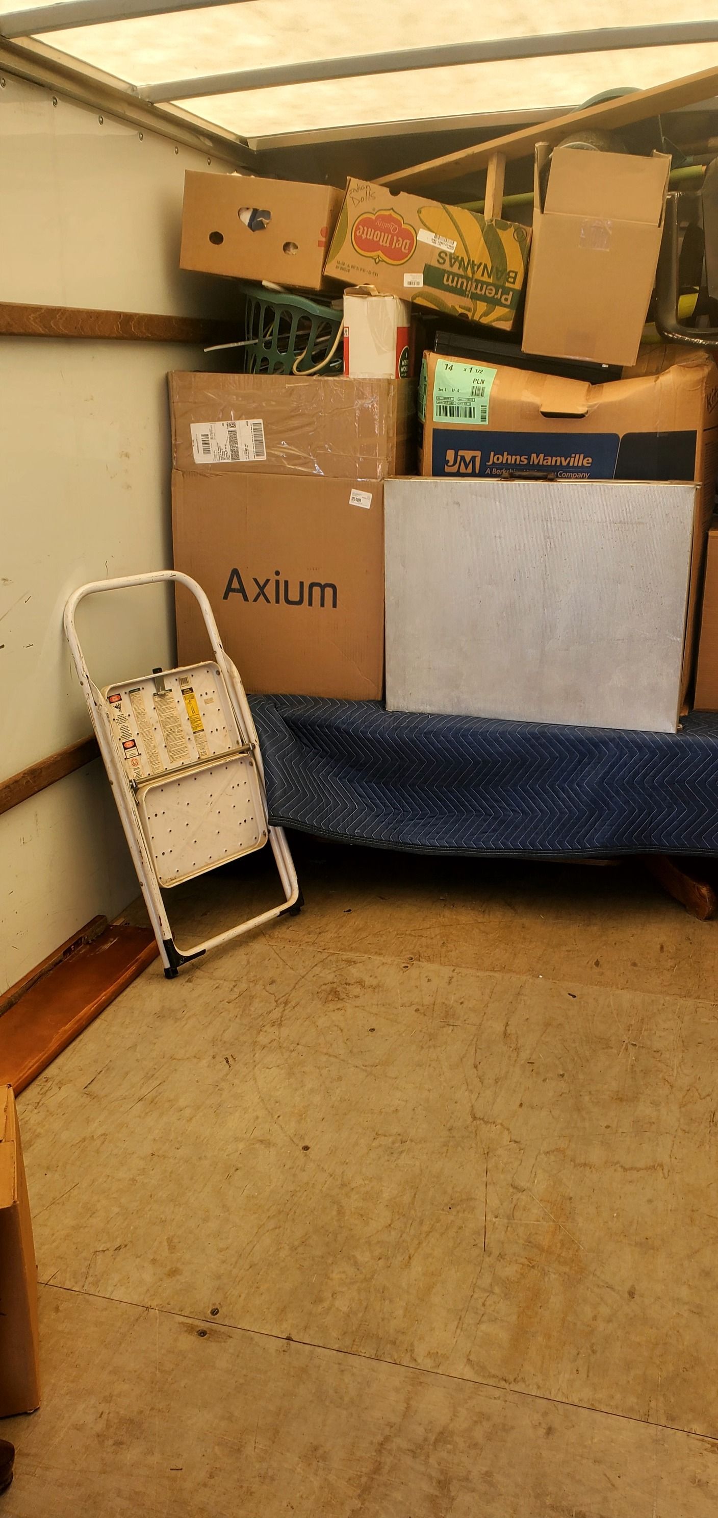 A room filled with boxes and a ladder.