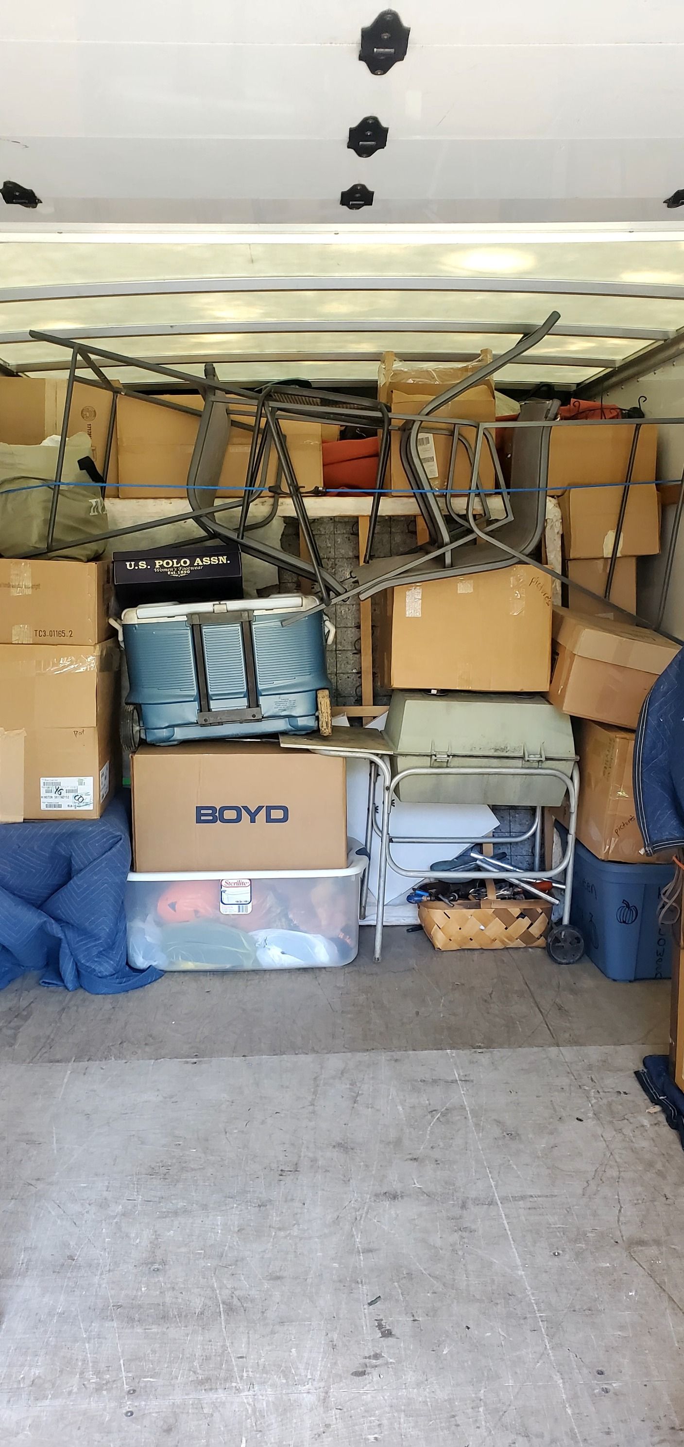 A truck is filled with lots of boxes and luggage.