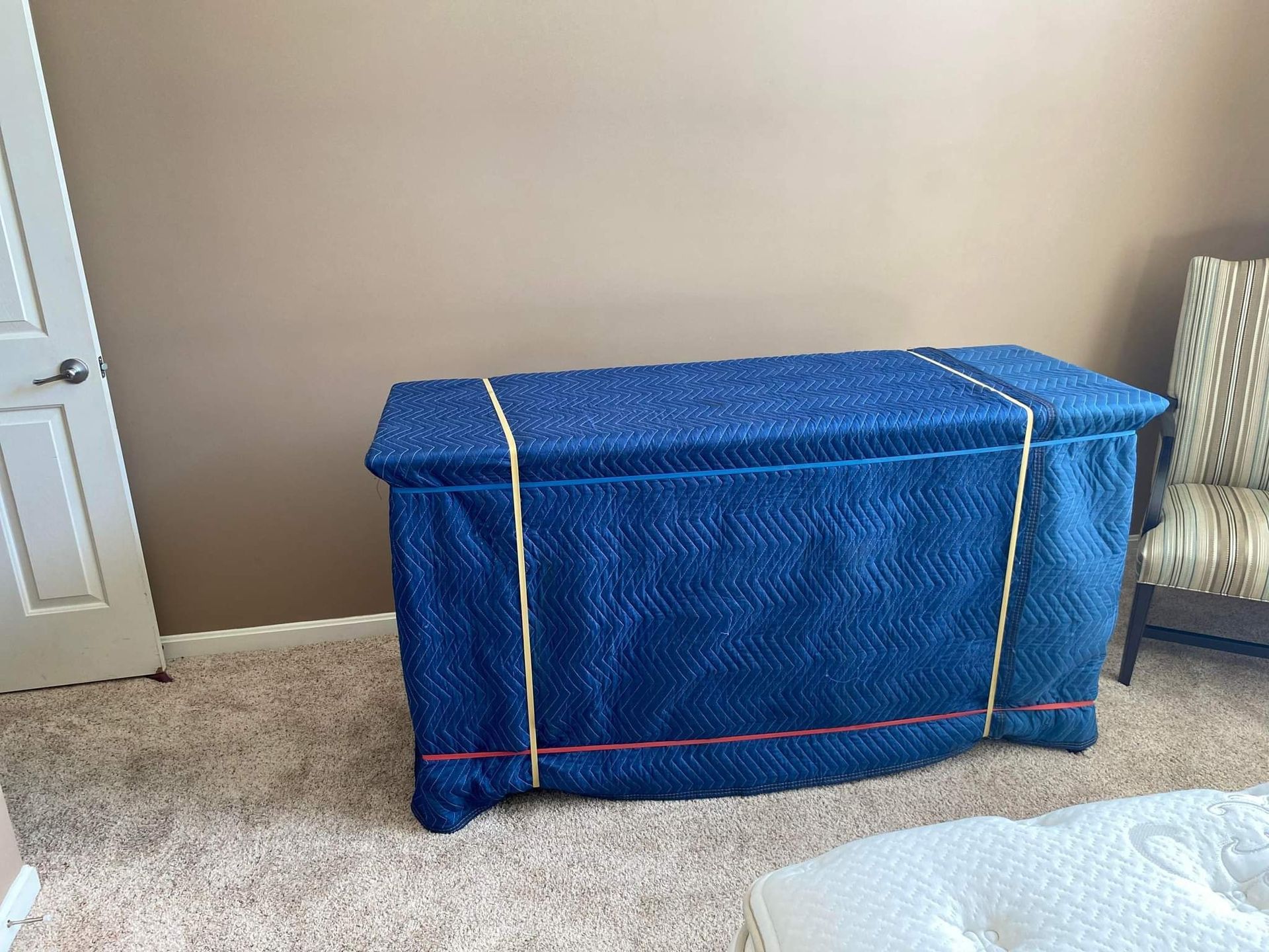 A blue blanket is covering a chest in a bedroom.