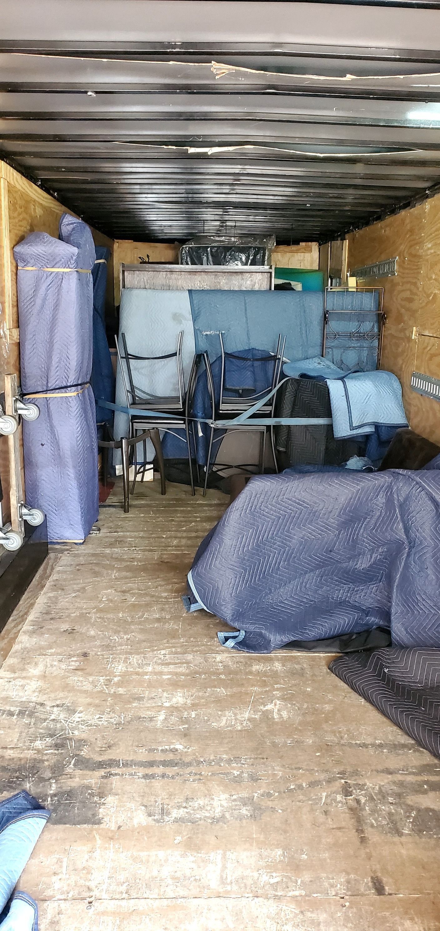 The inside of a moving truck filled with furniture and boxes.