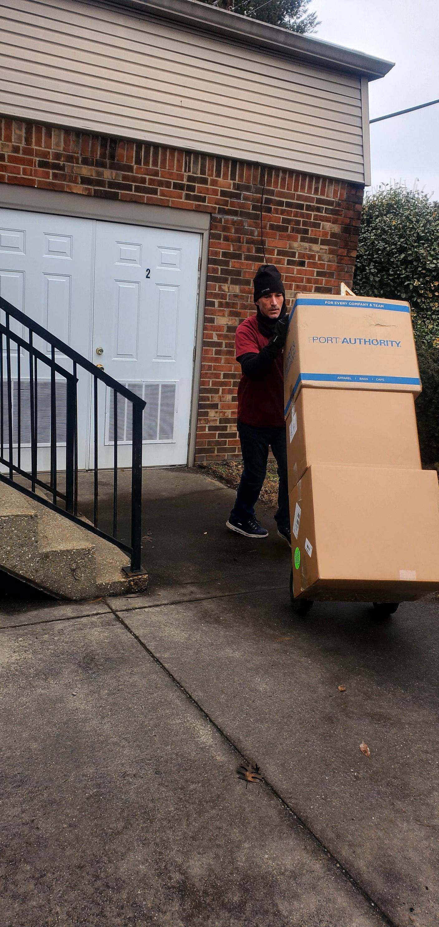 A man is pushing a cart with boxes on it.