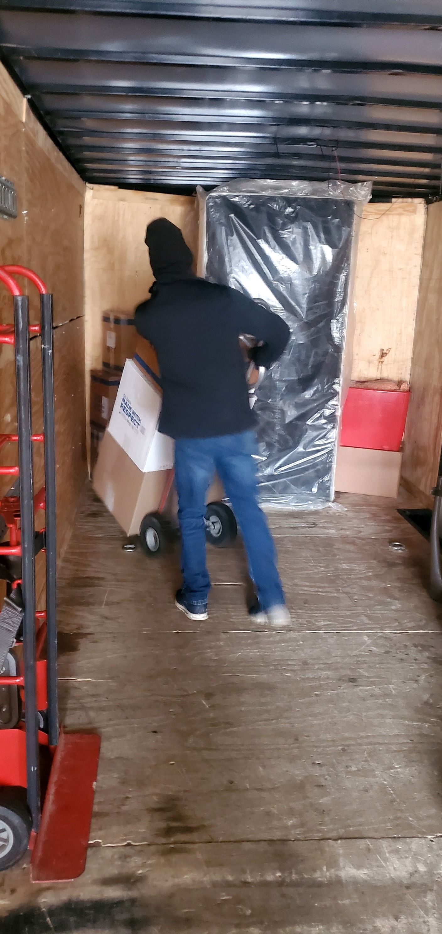 A man is pushing a box into a truck.