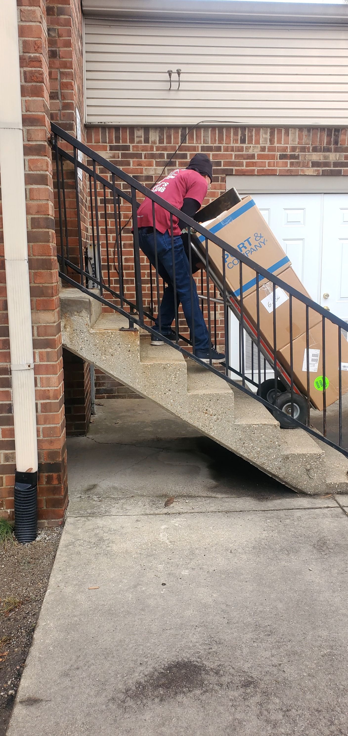 A man is pushing a box up a set of stairs.