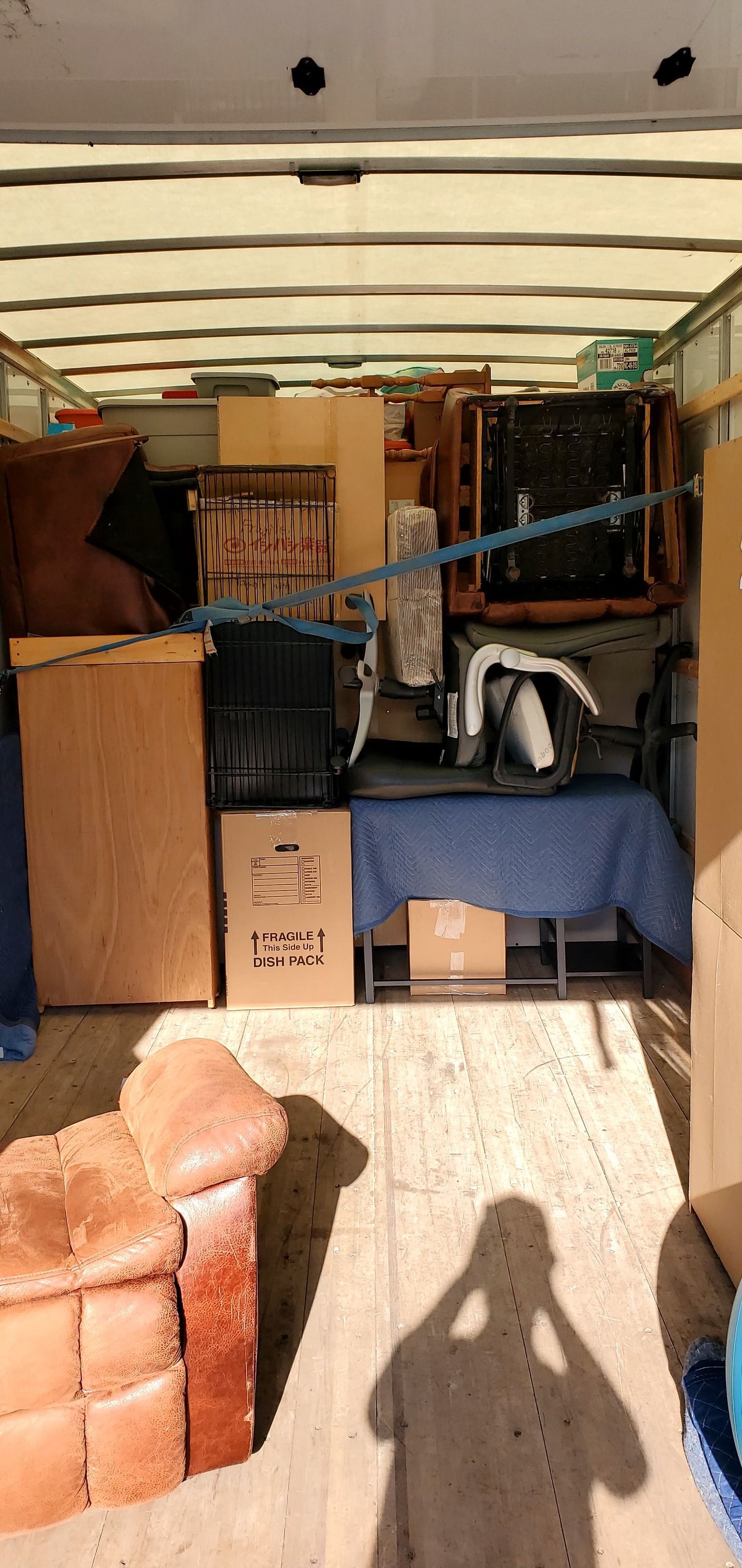 The inside of a moving truck filled with furniture and boxes.