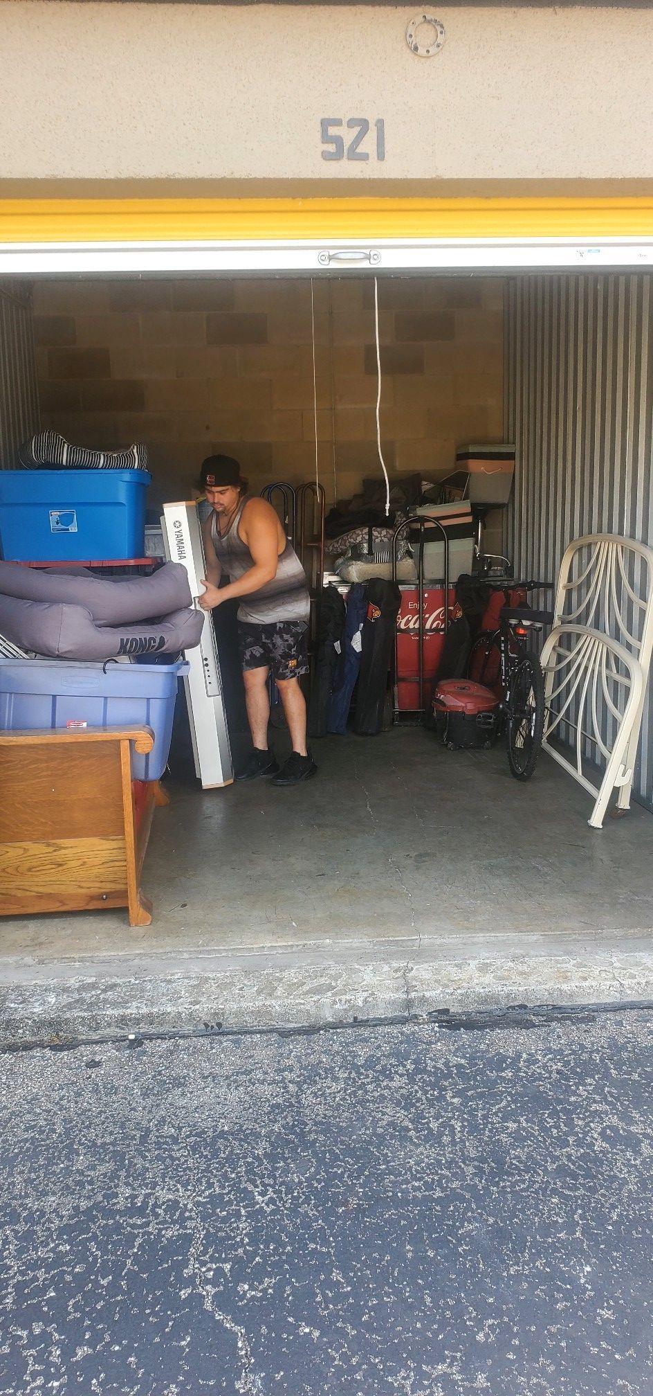 A man is standing in a garage filled with lots of furniture.