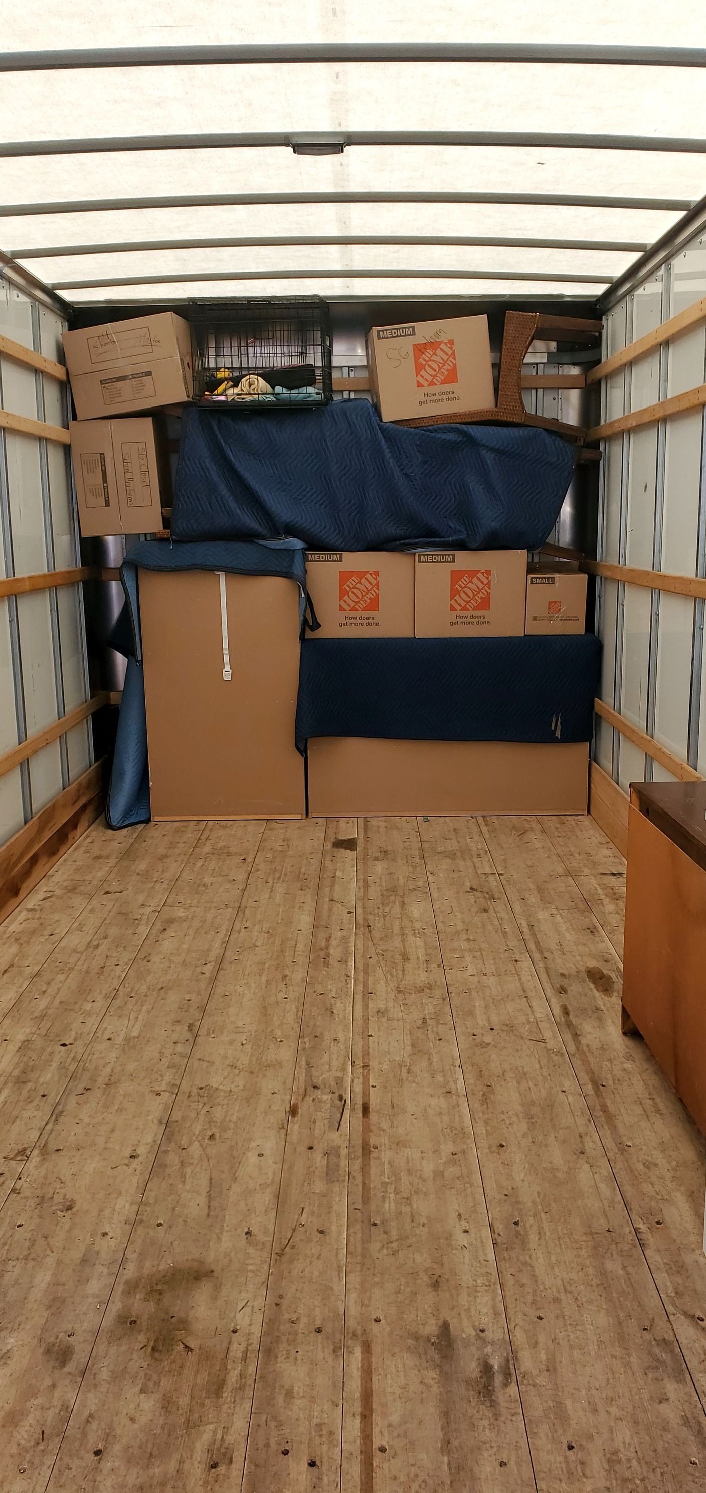 The inside of a moving truck filled with boxes and furniture.