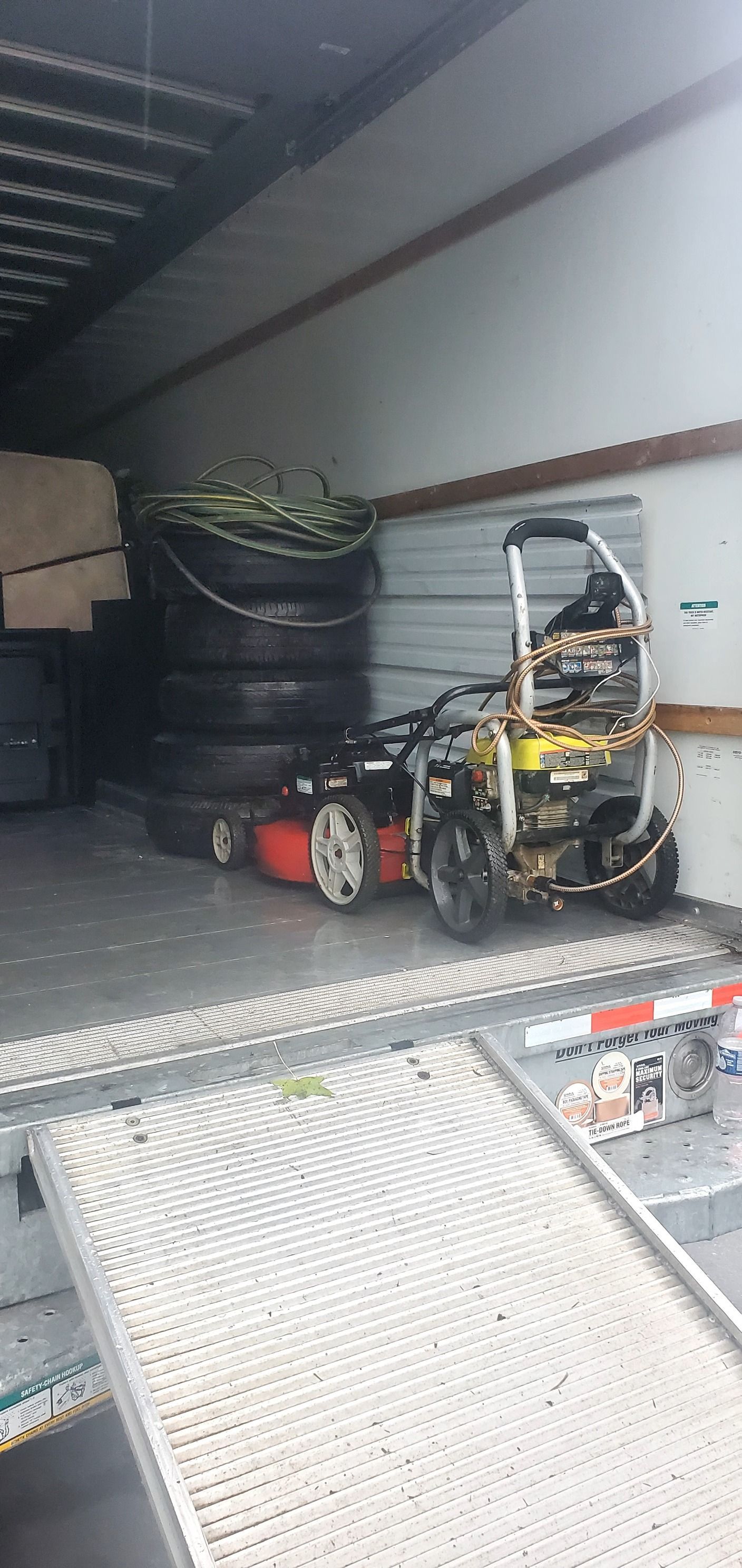 A lawn mower is parked in the back of a truck.