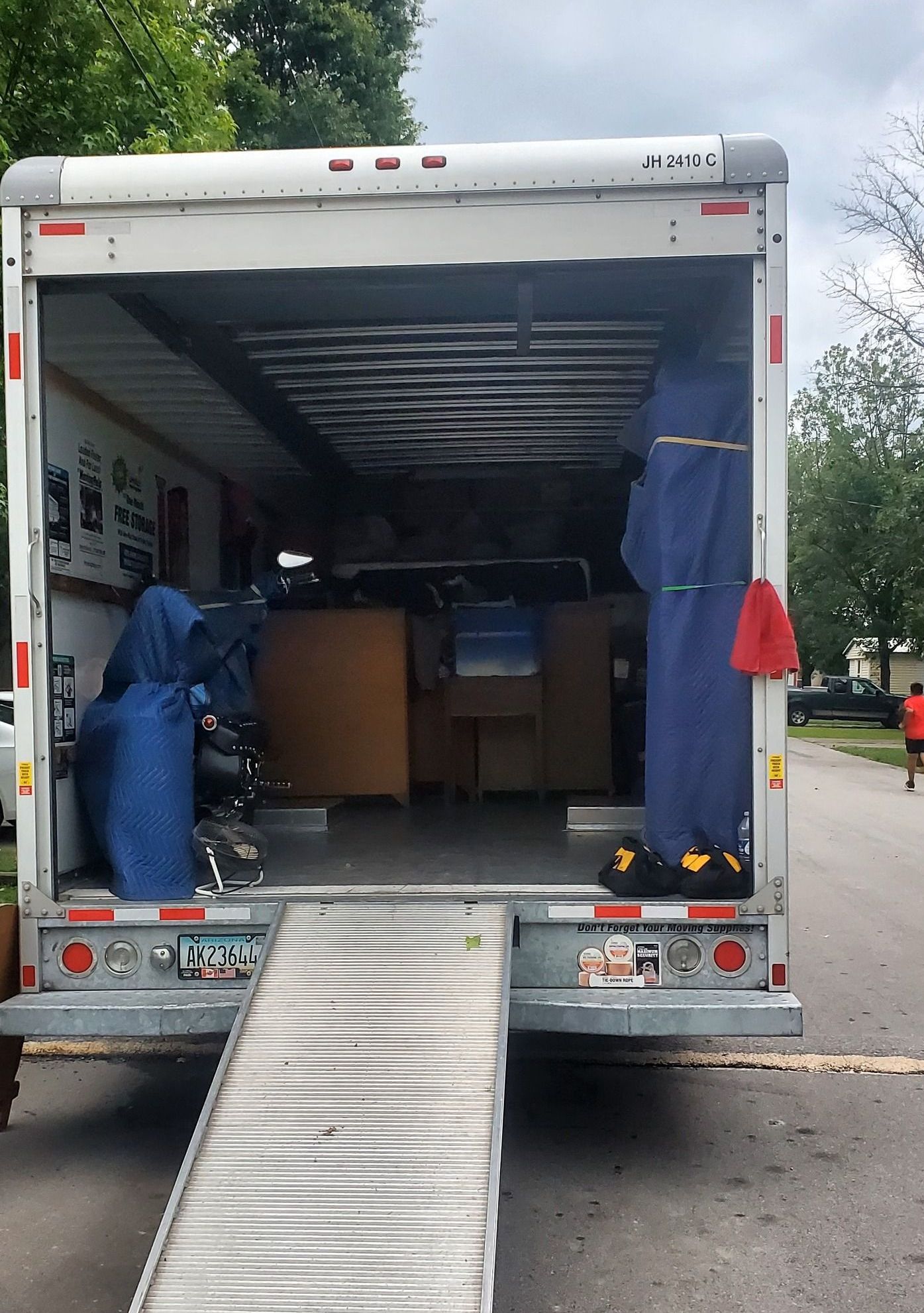 A moving truck is parked on the side of the road.
