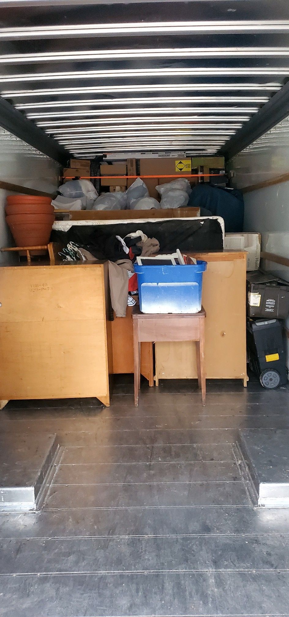 The inside of a moving truck filled with furniture and boxes.