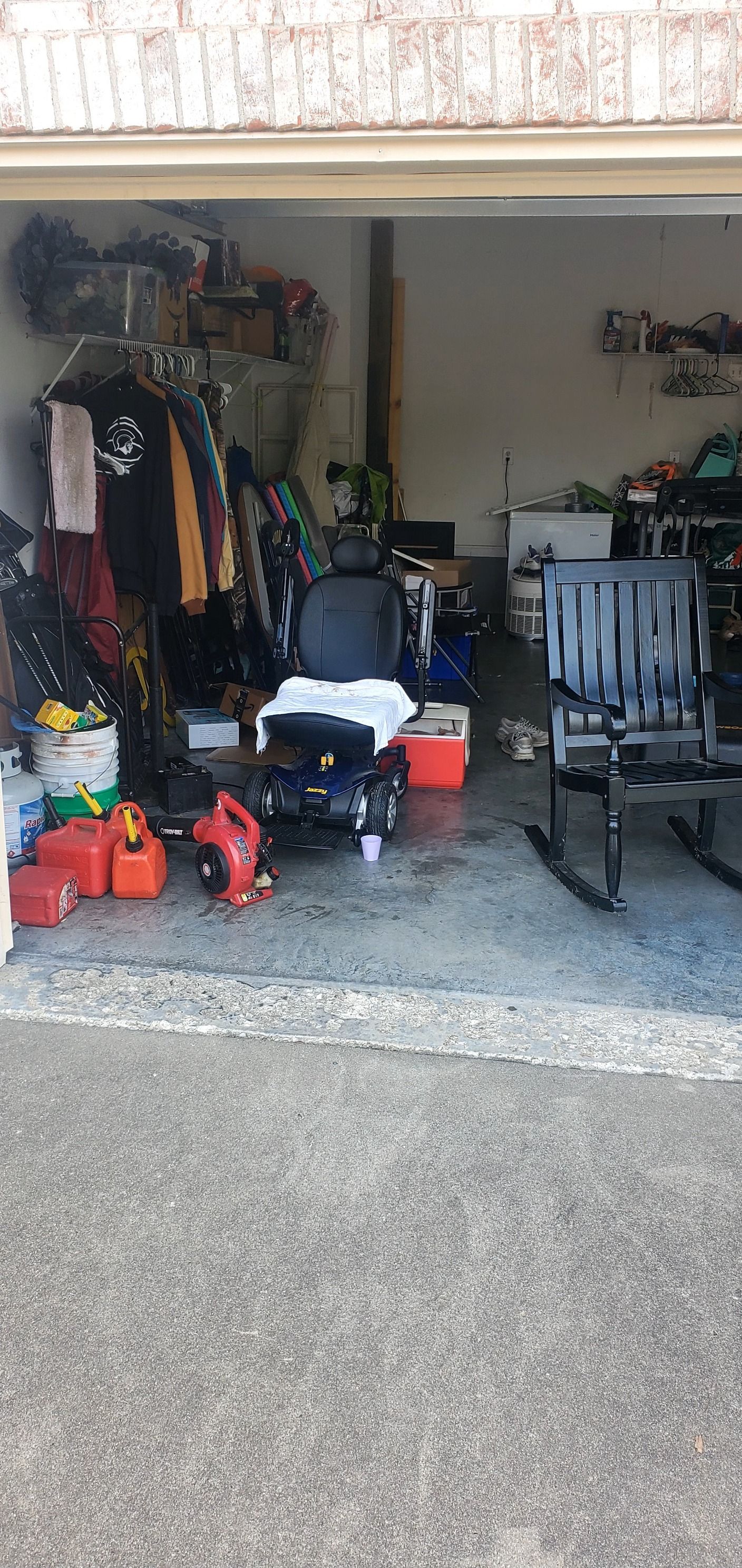 A garage filled with lots of junk and a rocking chair.