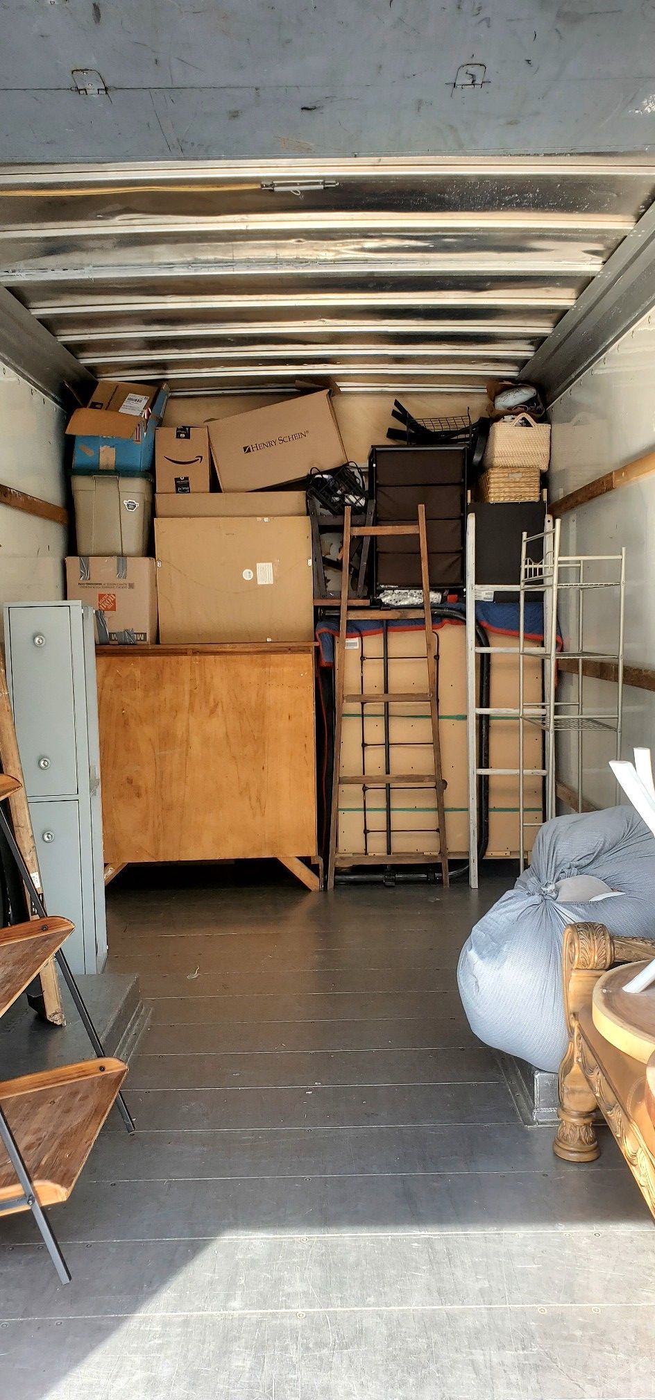 The inside of a moving truck filled with boxes and furniture.