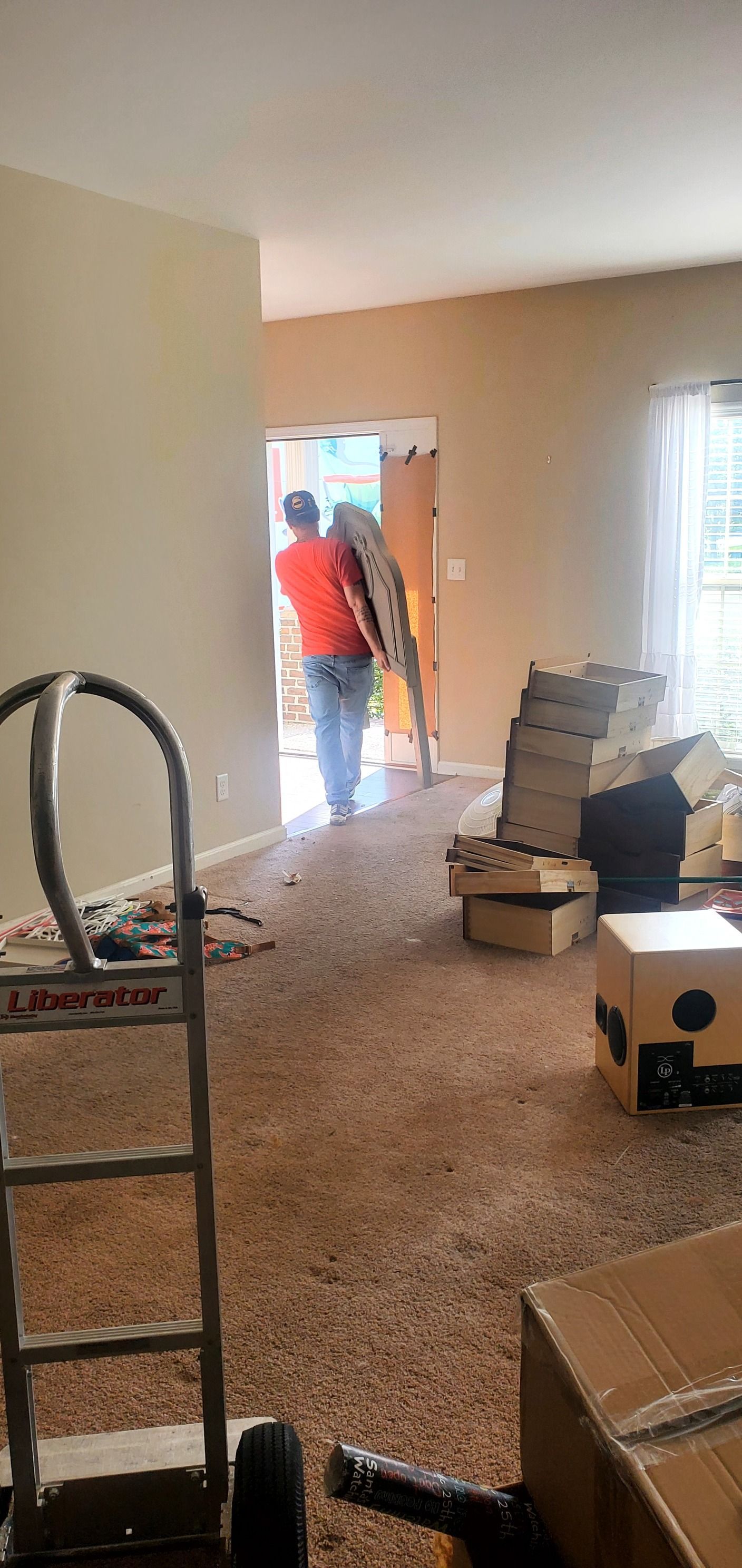 A man is carrying a ladder into a living room.