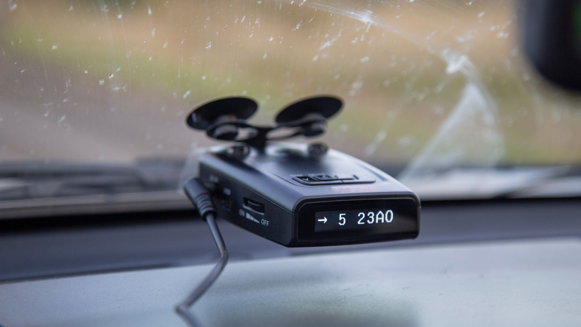 Small camera mounted near a car's rearview mirror on the windshield, facing forward.