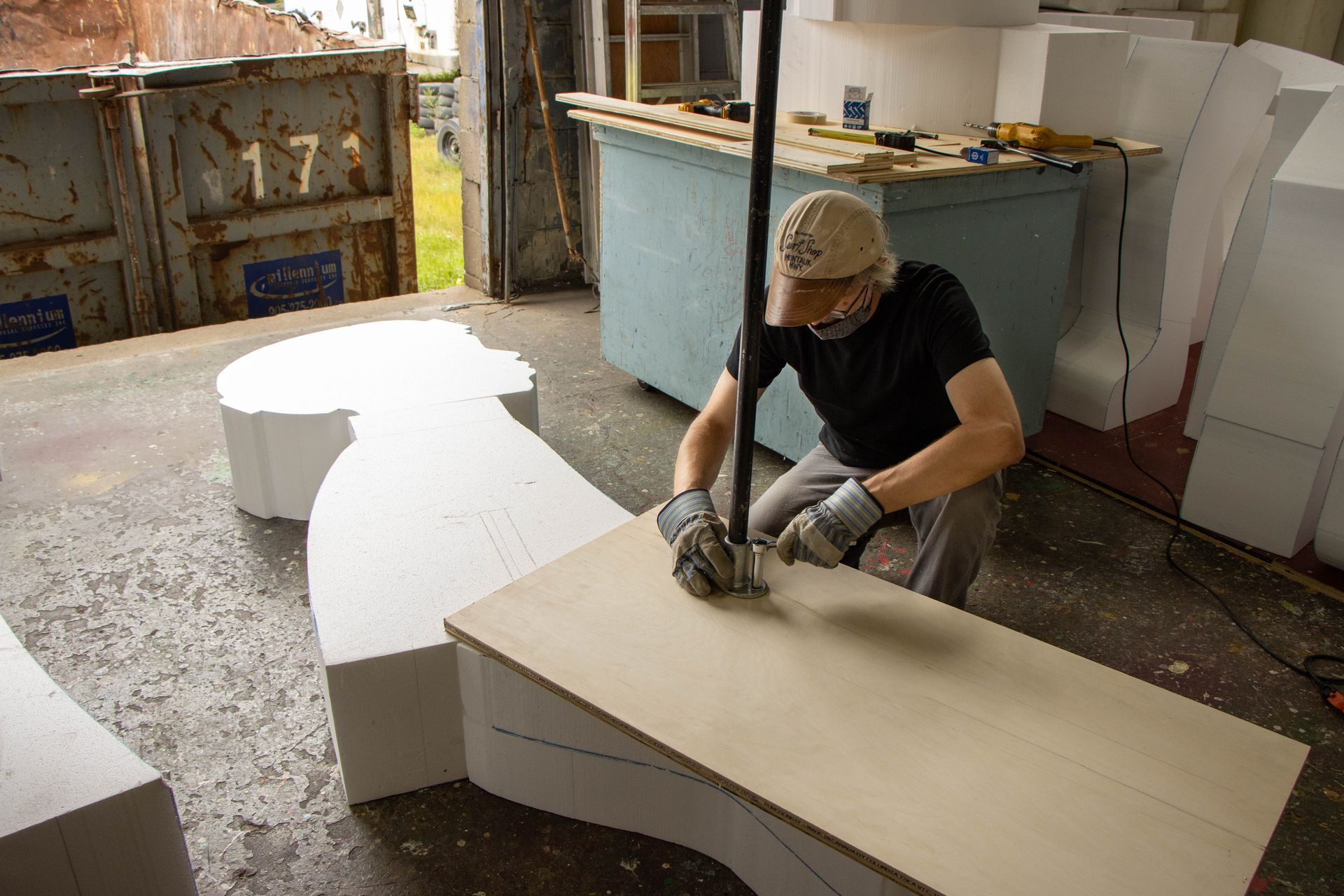 A man is working on a piece of wood in a workshop.