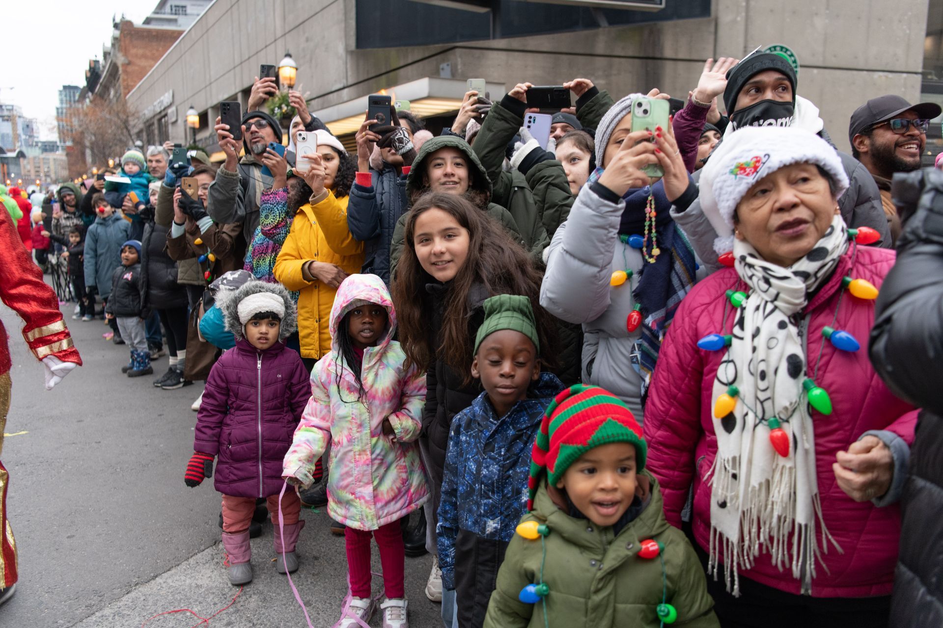 A large group of people are walking down a street.