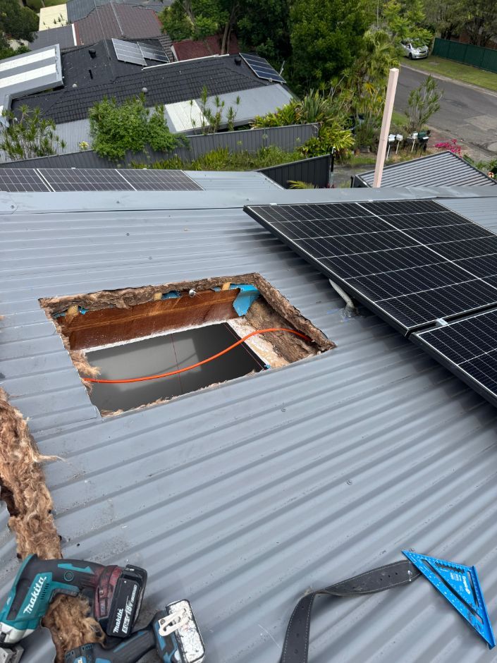 A Roof With a Hole in It and Solar Panels on It — Platinum Pride Roofing In Wyoming, NSW