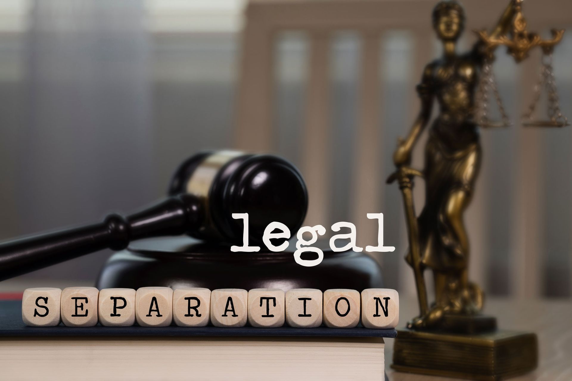 Gavel and Lady Justice statue next to wooden blocks spelling Gavel and Lady Justice statue next to wooden blocks spelling