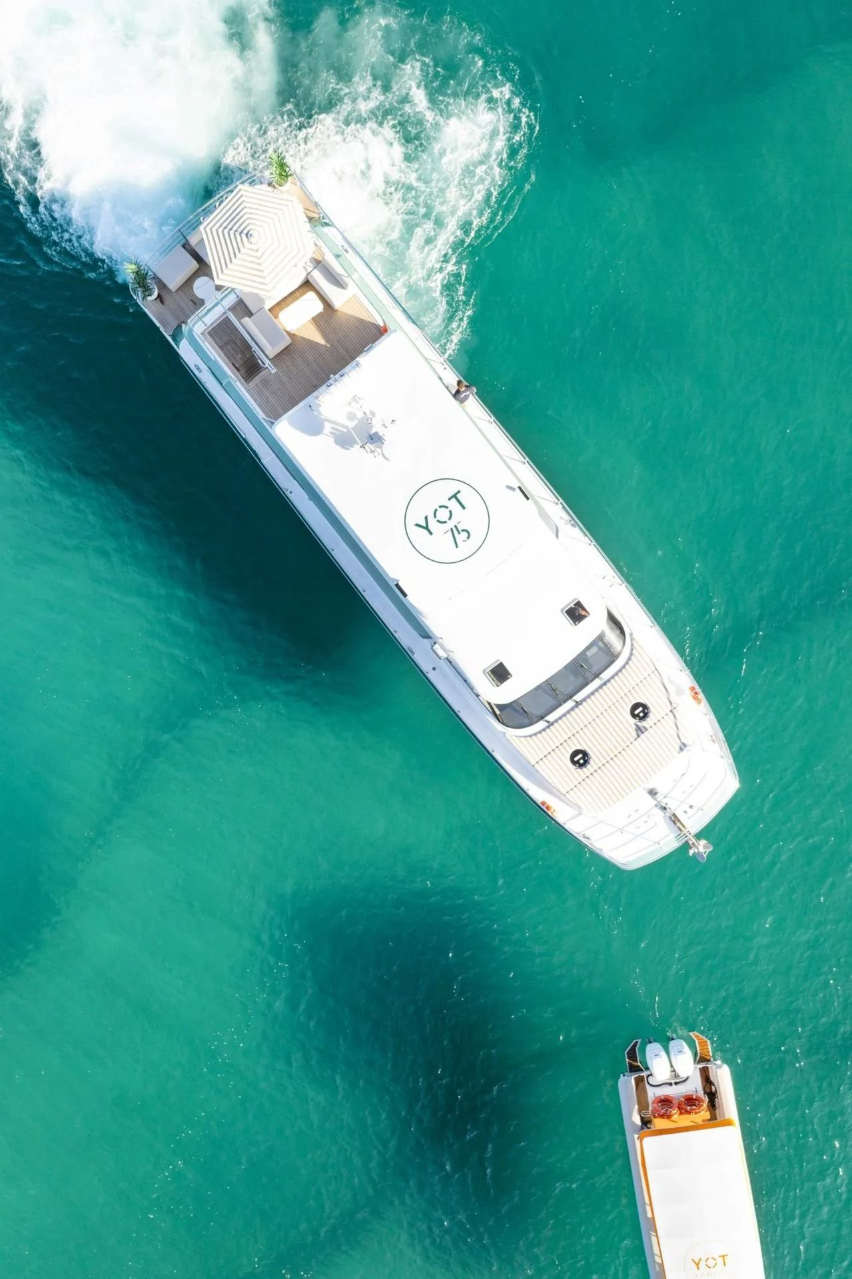 A top-down aerial view of a large white yacht marked