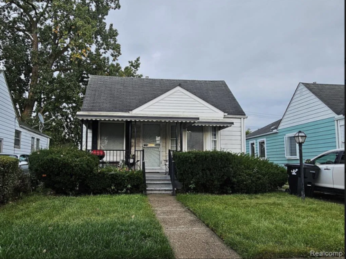 A small house with a car parked in front of it.