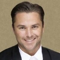A man in a suit and tie is smiling for the camera.