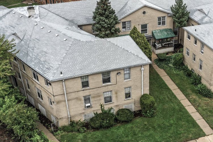 An aerial view of a large apartment building with a gray roof