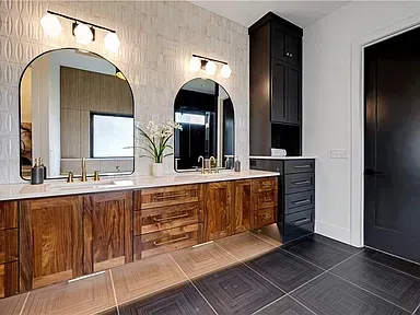 Modern bathroom vanity with double mirrors, warm wood cabinets, black doors, and dark tiled floor