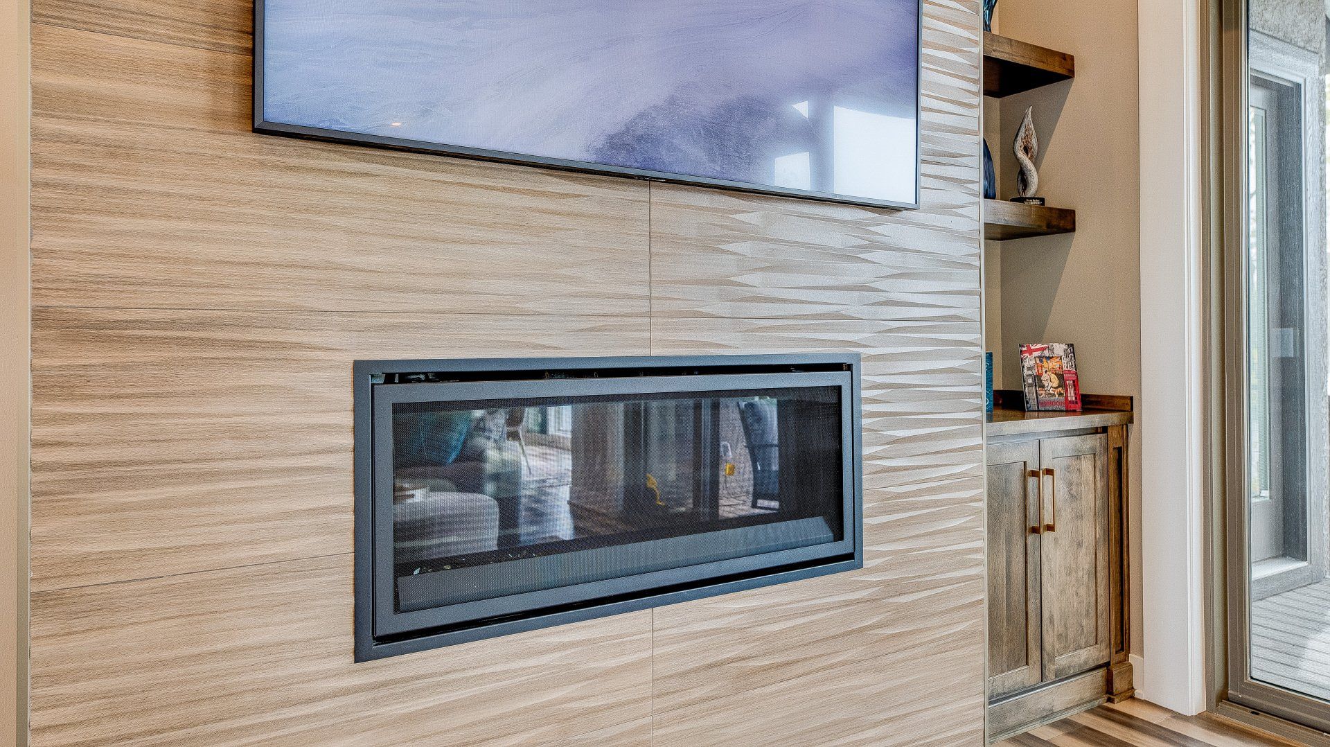 A living room with a fireplace and a flat screen tv on the wall.