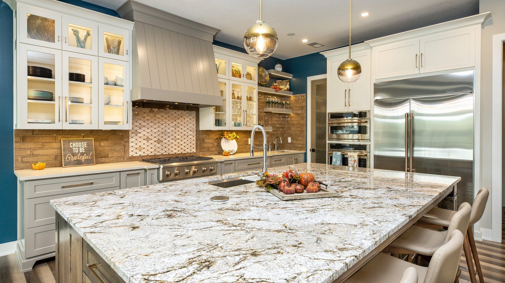 A kitchen with a large granite counter top and stainless steel appliances.