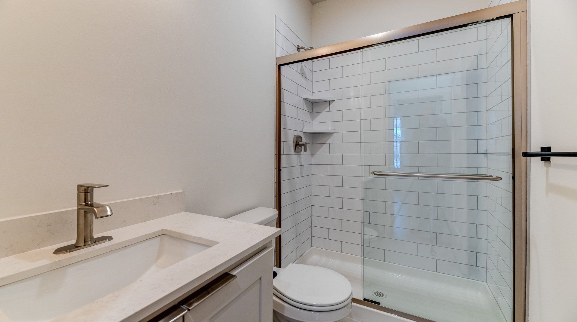 A bathroom with a toilet , sink , shower and bathtub.