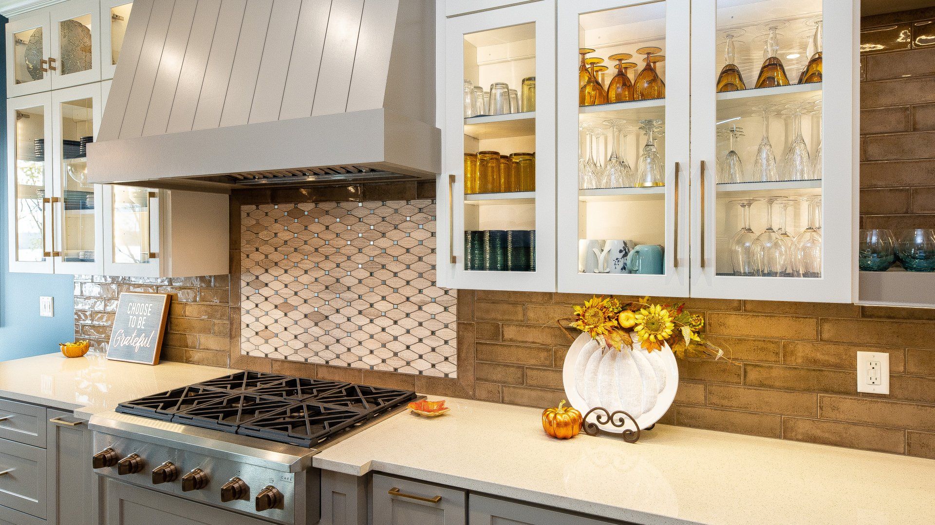 A kitchen with a stove and a vase of flowers on the counter.