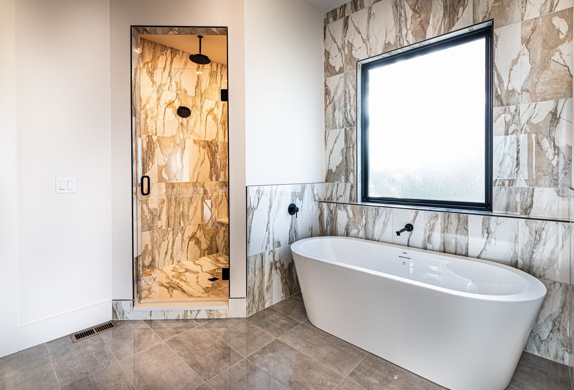 A bathroom with a tub , shower , and window.