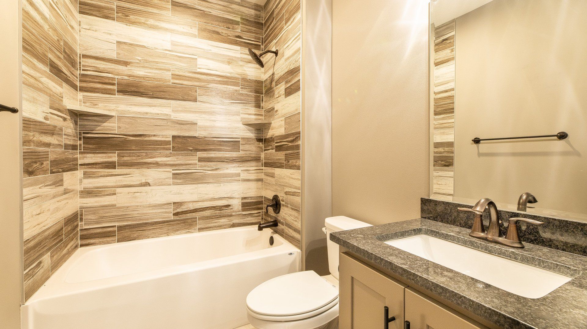 A bathroom with a tub , toilet , sink and mirror.