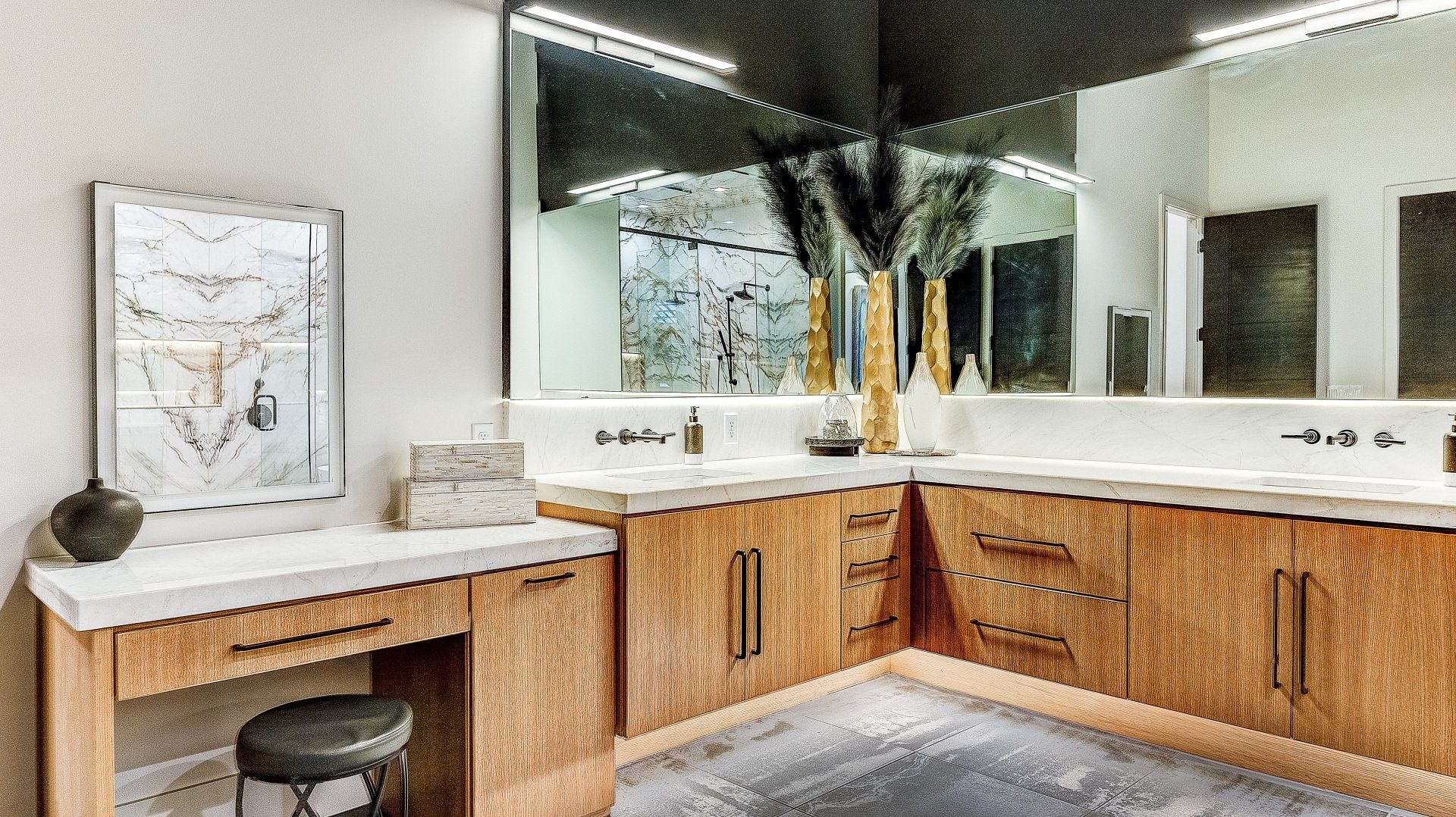 A bathroom with two sinks , a vanity , and a large mirror.