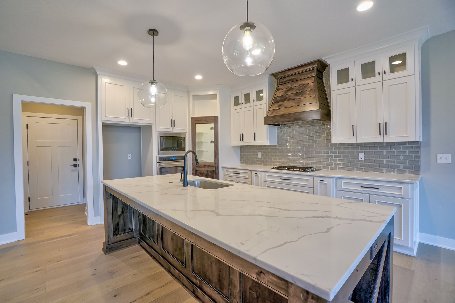 A kitchen with white cabinets and a large island in the middle.