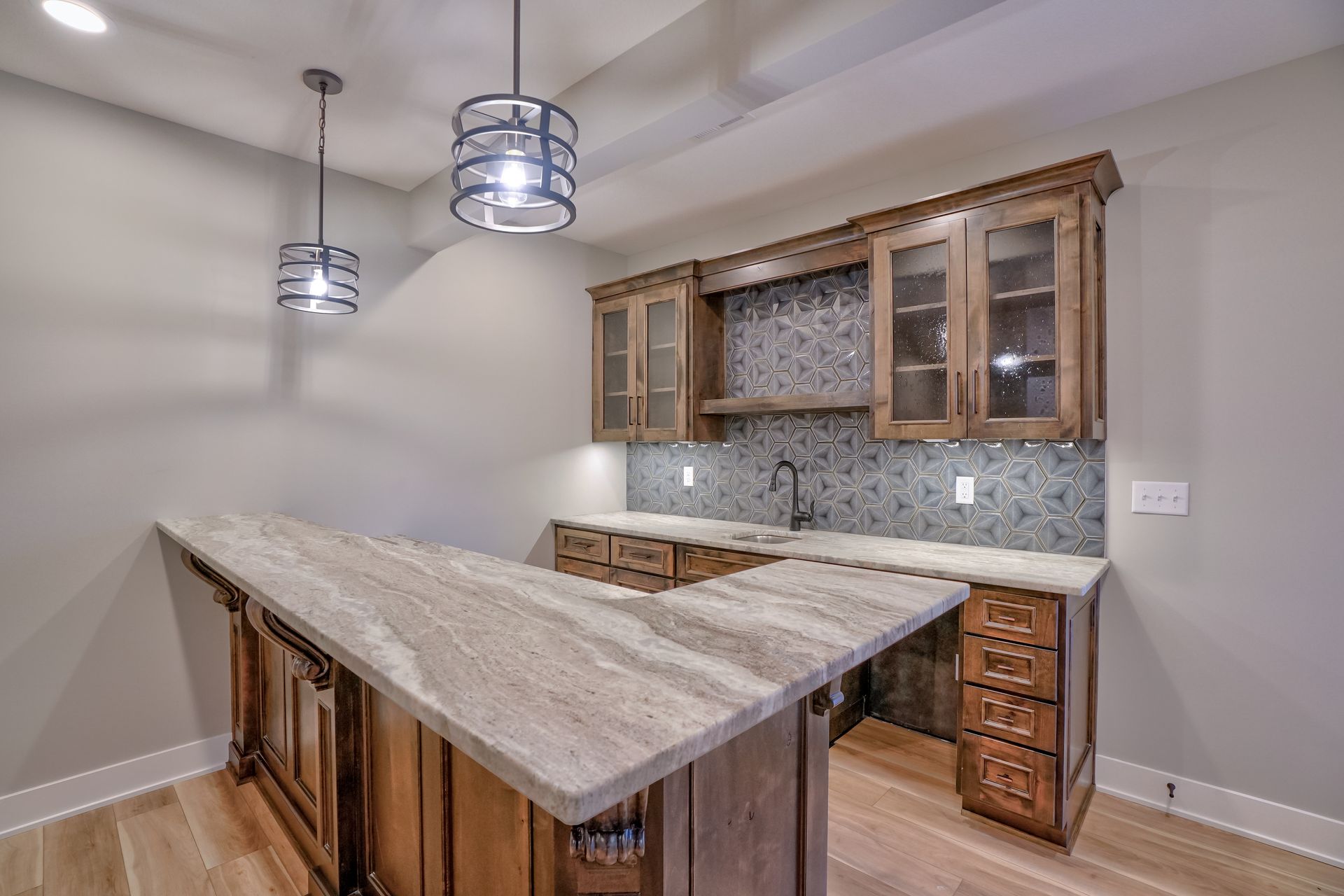 A kitchen with a large granite counter top and wooden cabinets.