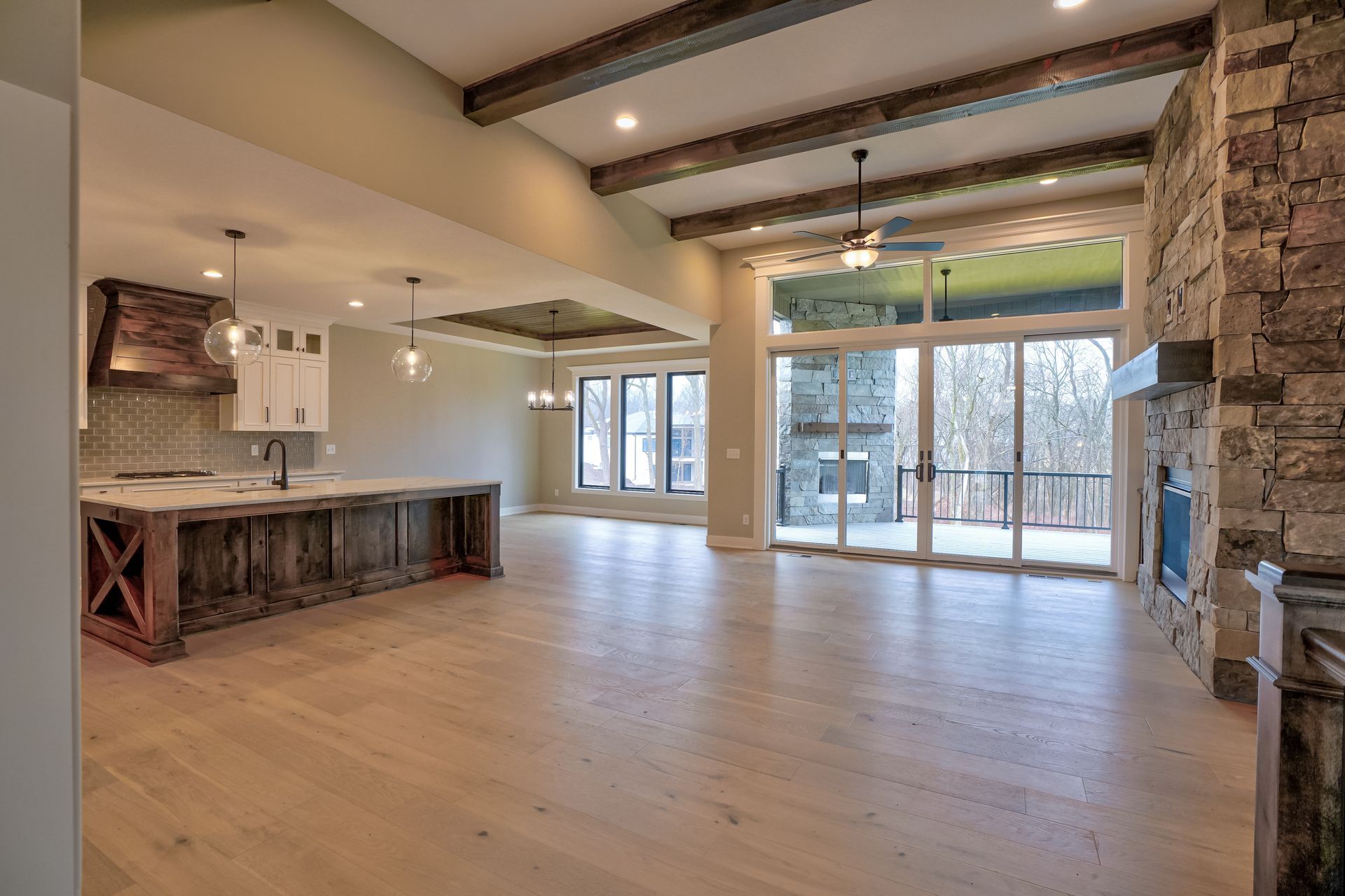A large empty room with a kitchen , living room , and fireplace.