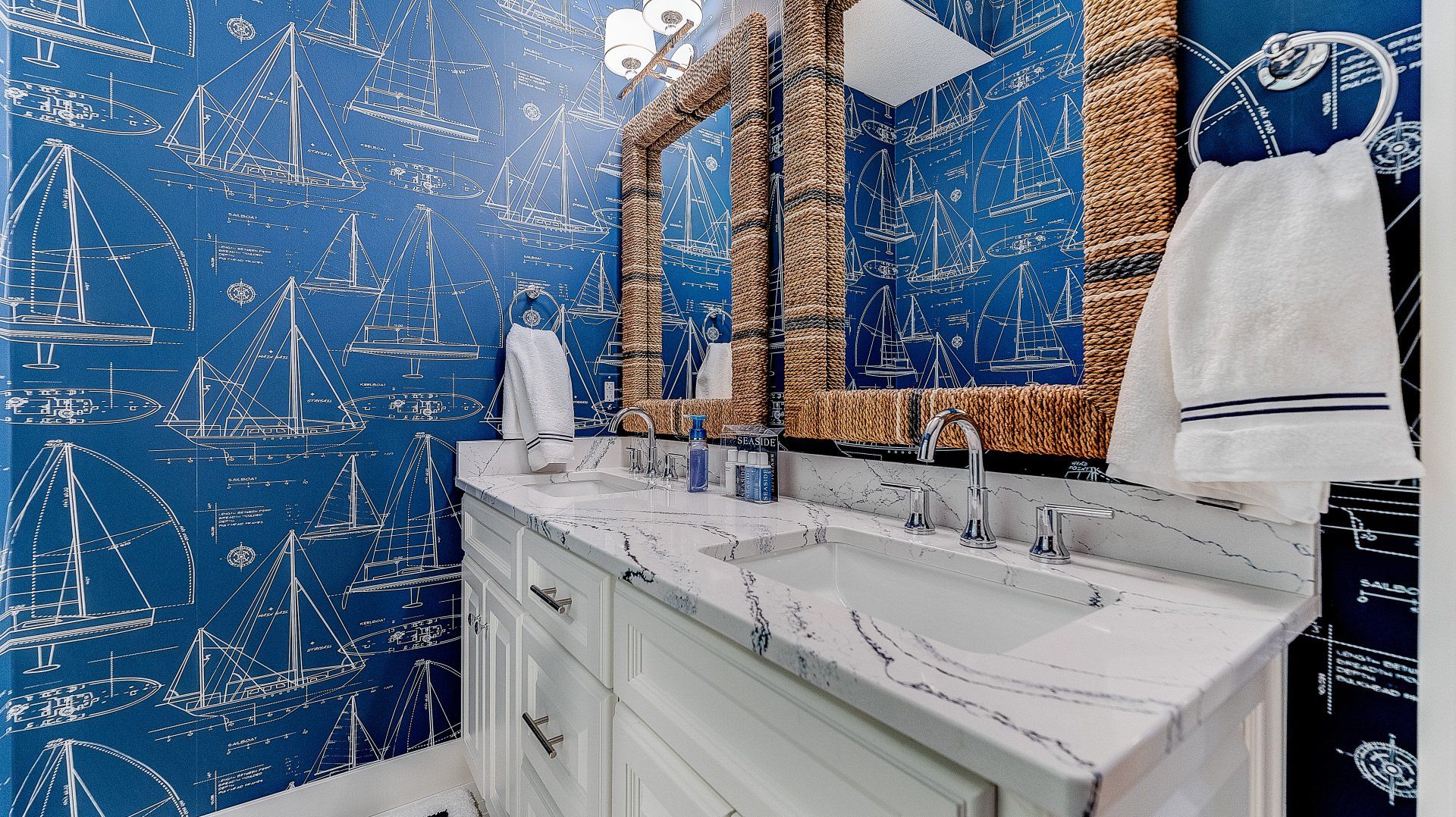 A bathroom with two sinks , two mirrors , and a blue wall.