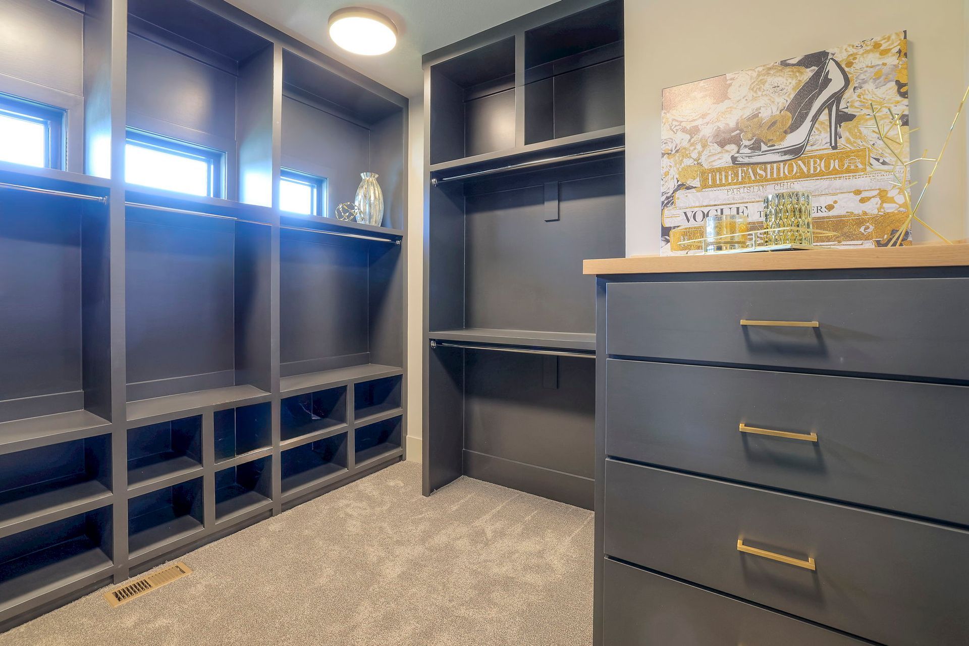 A walk in closet with lots of shelves and drawers.