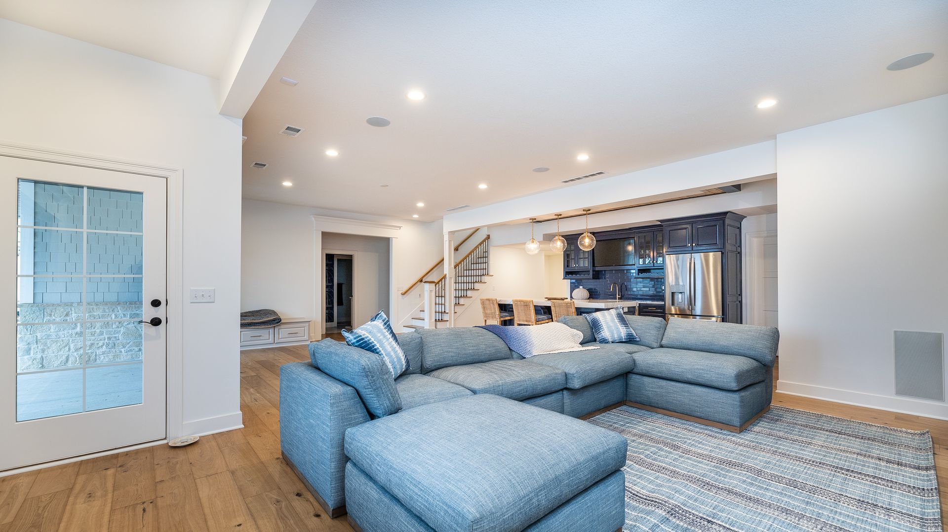 A living room with a large sectional couch and ottoman.