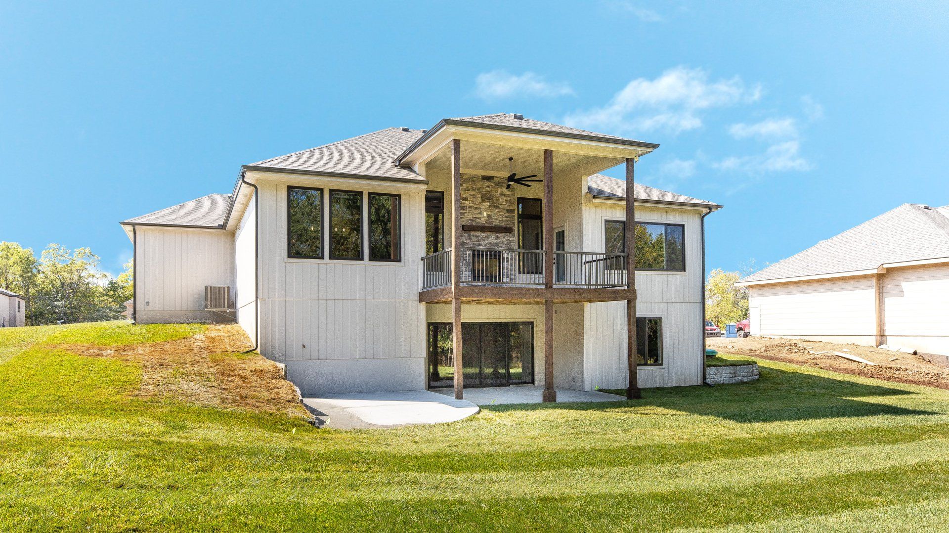 The back of a house with a large lawn in front of it.
